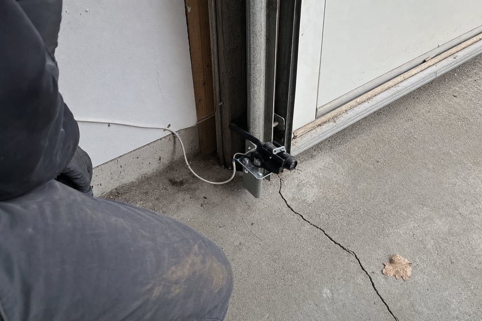 Safety sensor mounted near the bottom of a garage door track